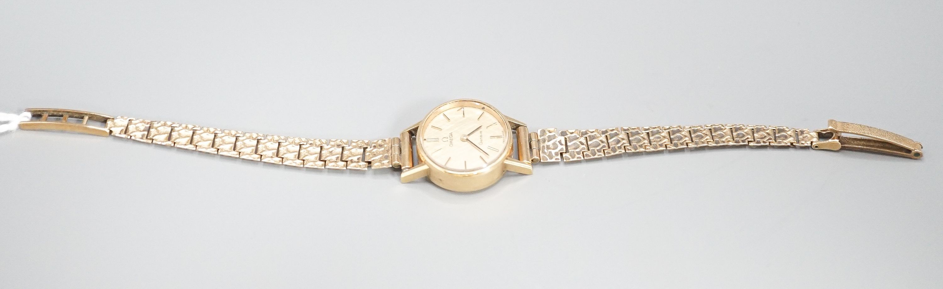 A lady's 1970's 9ct gold Omega manual wind wrist watch, on a 9ct gold bracelet, overall 18.5cm